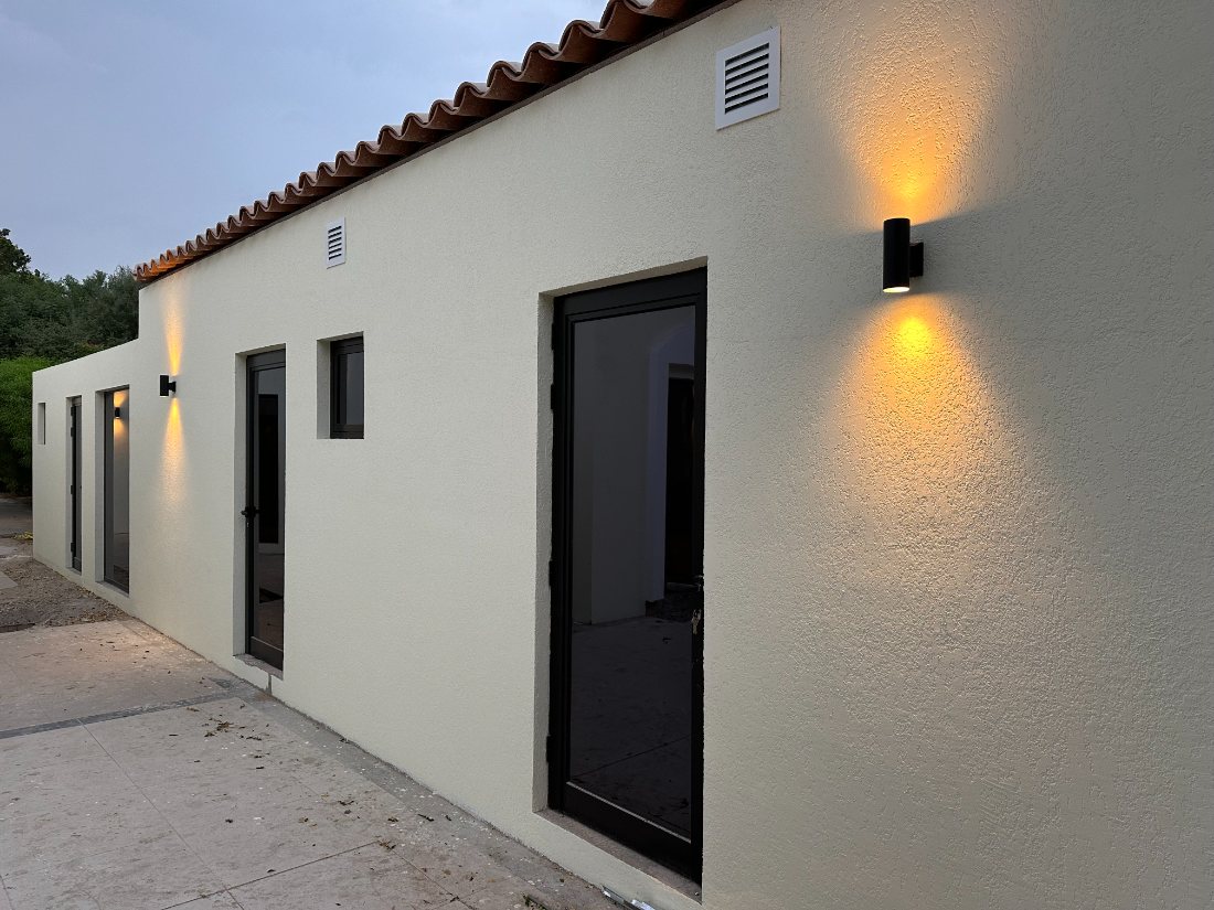 Finished rendered villa wall with exterior lighting at dusk