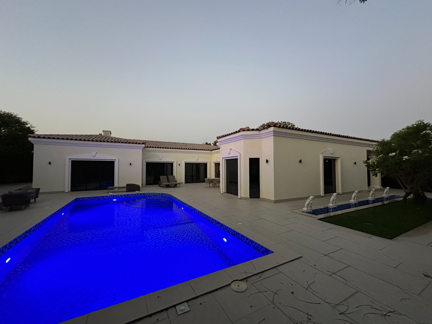 Villa facade with warm exterior lighting at dusk